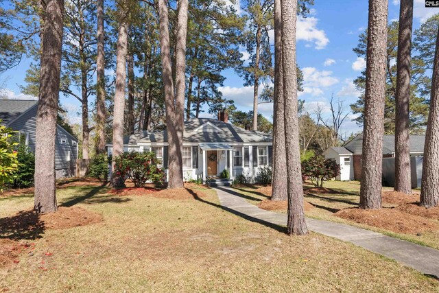 view of front of property featuring a chimney, a residential view, fence, and a front lawn
