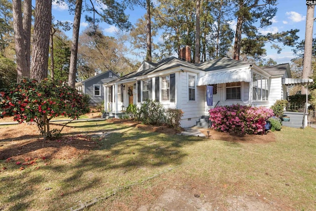 exterior space with a chimney, a front lawn, and crawl space