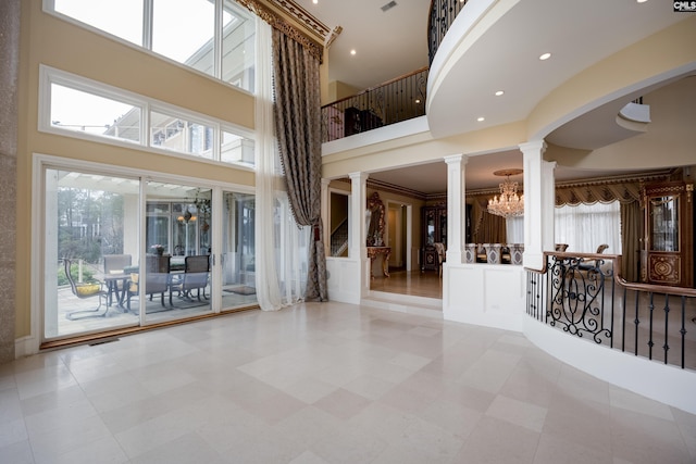 interior space with recessed lighting, decorative columns, a chandelier, a high ceiling, and visible vents