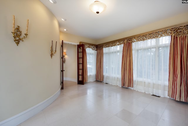 spare room featuring baseboards and recessed lighting