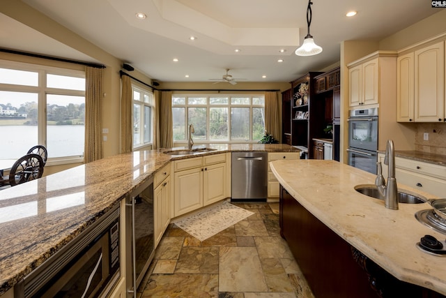 kitchen featuring cream cabinetry, a sink, appliances with stainless steel finishes, and beverage cooler