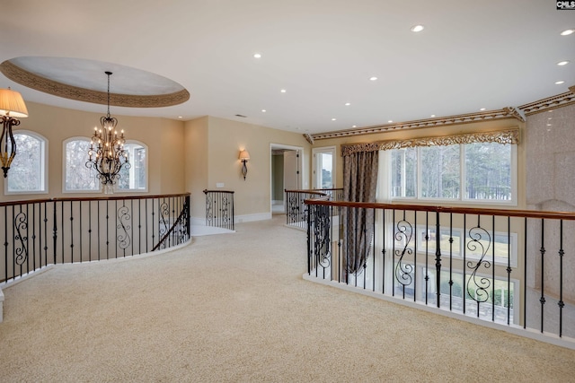 corridor featuring a healthy amount of sunlight, an inviting chandelier, and carpet
