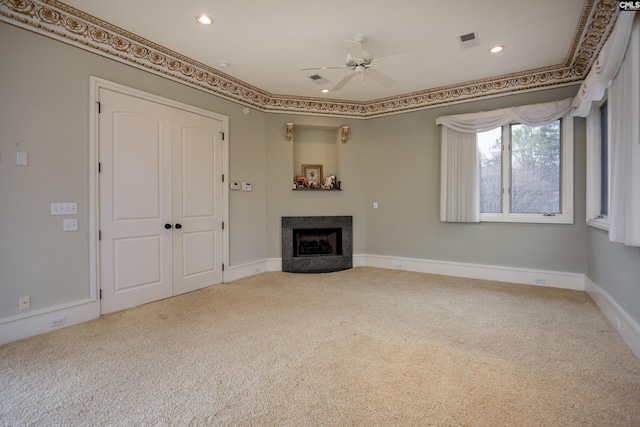 unfurnished living room featuring a ceiling fan, a fireplace, baseboards, visible vents, and carpet
