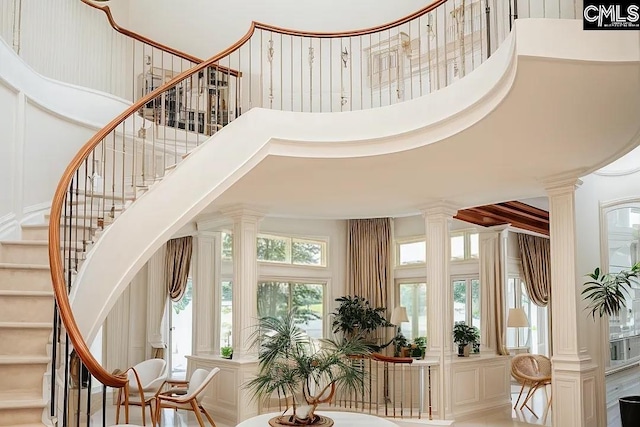 entrance foyer featuring ornate columns, a high ceiling, and stairway
