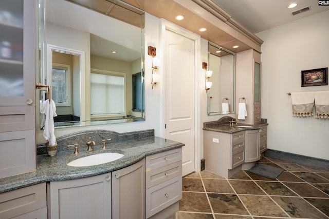 bathroom with visible vents, recessed lighting, a sink, and two vanities