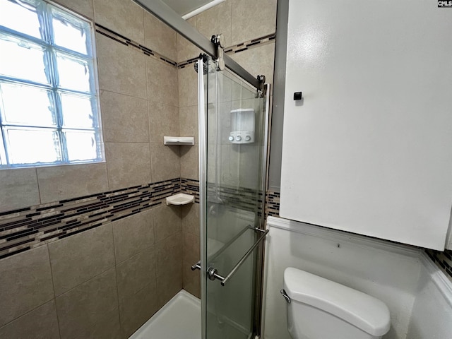 full bathroom featuring toilet and an enclosed shower