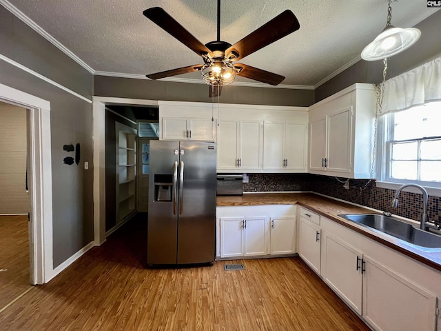 kitchen with visible vents, white cabinets, a sink, and stainless steel refrigerator with ice dispenser
