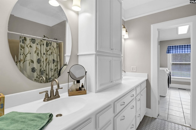 full bathroom featuring washing machine and dryer, a sink, tile patterned flooring, and double vanity