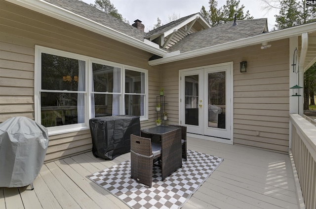 wooden deck with a grill and french doors