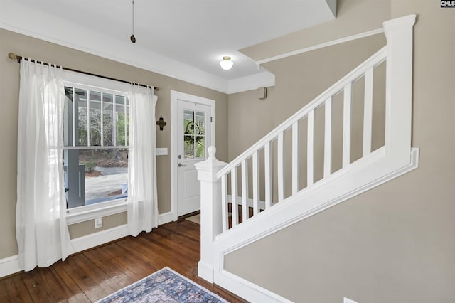 entryway with wood-type flooring, baseboards, and stairs