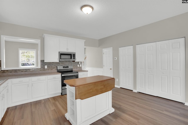 1827 Lake Carolina Dr, Columbia, SC 29229 - kitchen with a center island, white cabinetry, light wood-style floors, and stainless steel appliances