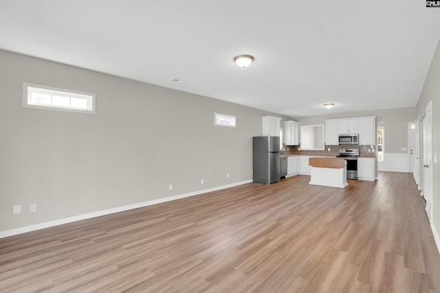 1827 Lake Carolina Dr, Columbia, SC 29229 - unfurnished living room with baseboards, light wood-style floors, and a healthy amount of sunlight
