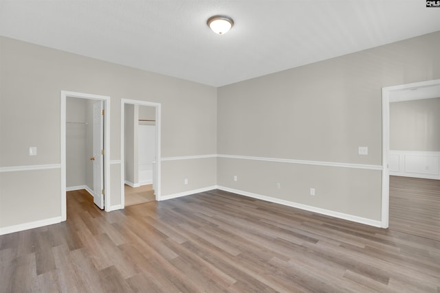 1827 Lake Carolina Dr, Columbia, SC 29229 - unfurnished bedroom with a closet, a walk in closet, baseboards, and wood finished floors