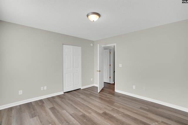 1827 Lake Carolina Dr, Columbia, SC 29229 - unfurnished bedroom with a textured ceiling, baseboards, and wood finished floors