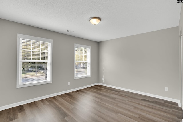 1827 Lake Carolina Dr, Columbia, SC 29229 - empty room featuring wood finished floors, a textured ceiling, baseboards, and visible vents