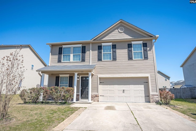 traditional-style house featuring a front yard, stone siding, concrete driveway, fence, and an attached garage