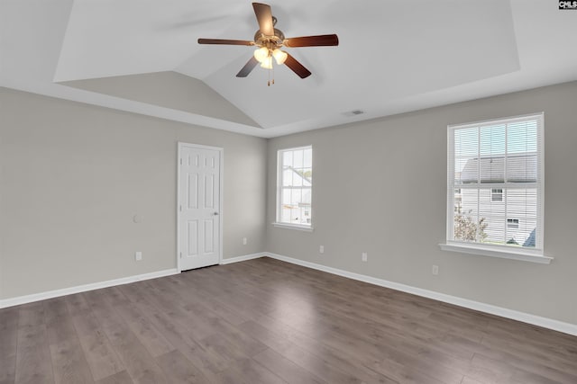 spare room featuring dark wood-style flooring, visible vents, baseboards, ceiling fan, and lofted ceiling