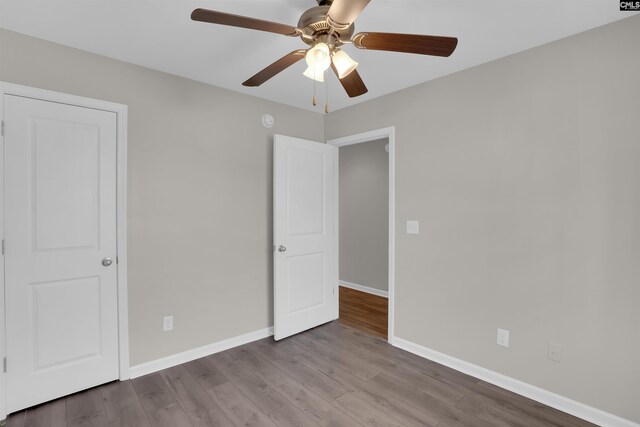 unfurnished bedroom with a ceiling fan, baseboards, and wood finished floors
