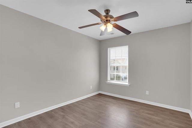 unfurnished room with visible vents, baseboards, ceiling fan, and wood finished floors