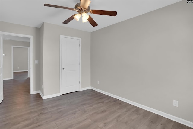 unfurnished bedroom featuring baseboards, wood finished floors, and a ceiling fan