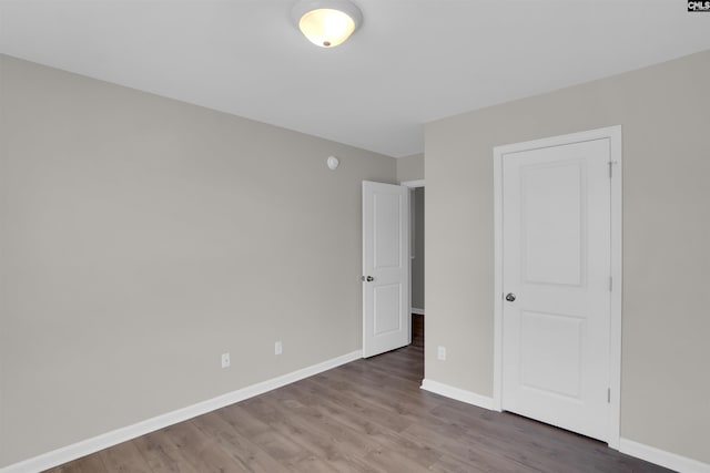 unfurnished bedroom with baseboards and wood finished floors