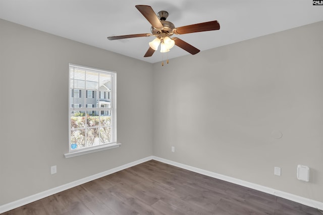 spare room featuring dark wood-style flooring, baseboards, and ceiling fan