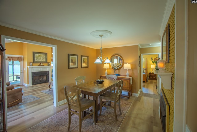 dining room featuring ornamental molding, light wood-style floors, and a fireplace