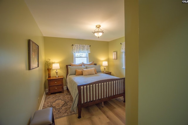 bedroom with baseboards and wood finished floors