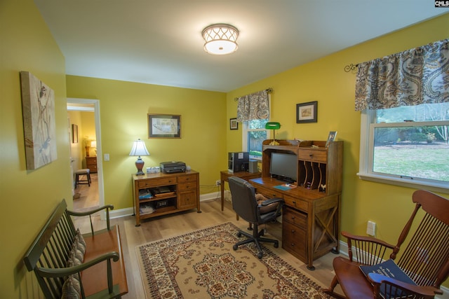 home office featuring baseboards and light wood finished floors