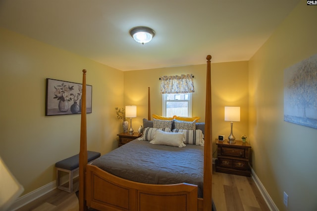 bedroom featuring light wood finished floors and baseboards