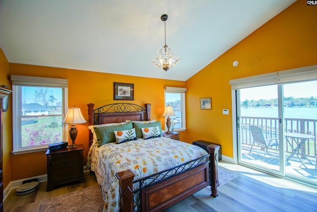 bedroom featuring lofted ceiling, baseboards, a chandelier, access to exterior, and wood finished floors