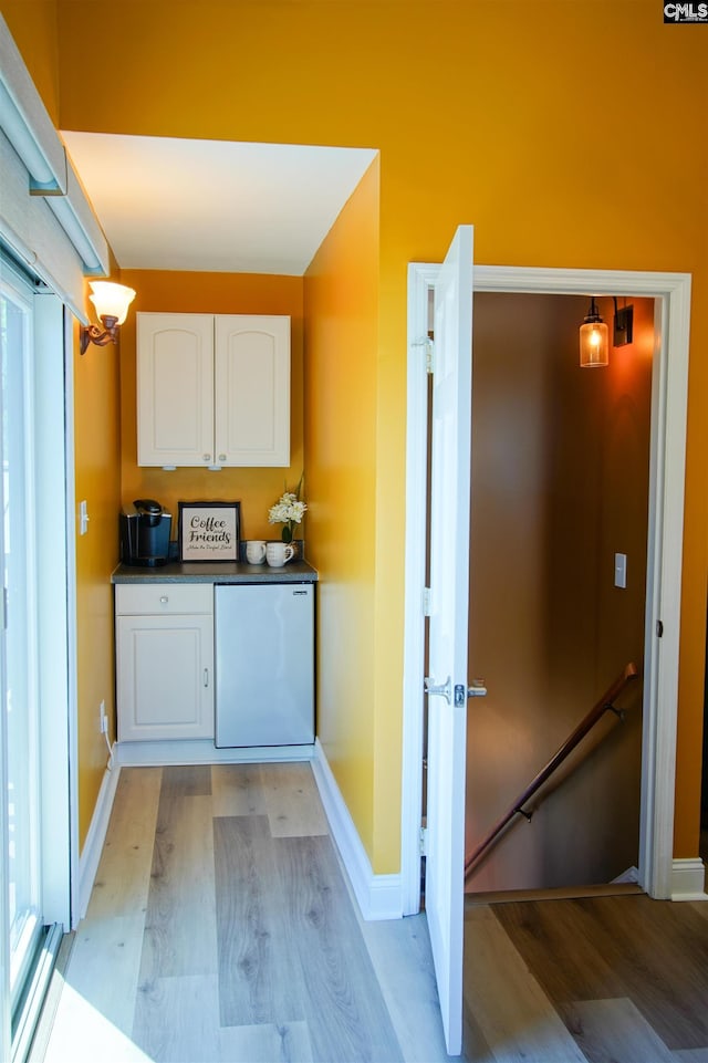 washroom with baseboards and light wood-style flooring