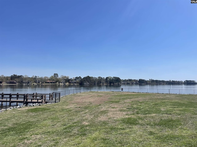 dock area with a water view and a lawn