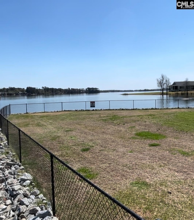view of yard featuring a water view and fence