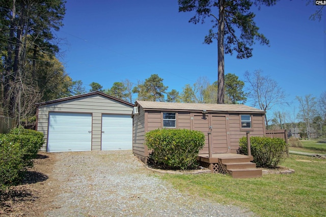 view of front of home with an outdoor structure, a garage, and a front lawn