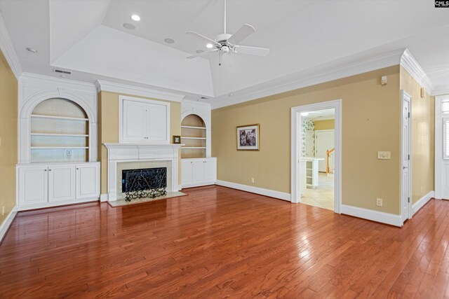 unfurnished living room with wood-type flooring, ornamental molding, baseboards, ceiling fan, and built in features