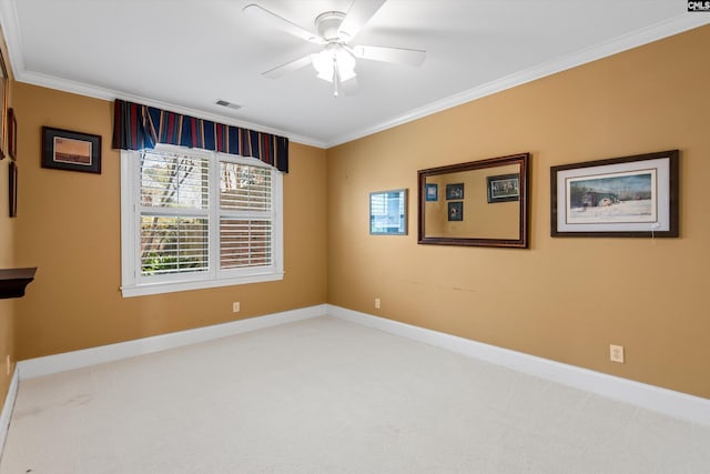 carpeted spare room featuring baseboards, ornamental molding, visible vents, and ceiling fan