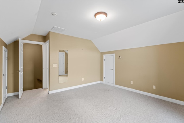 additional living space featuring light carpet, baseboards, and vaulted ceiling