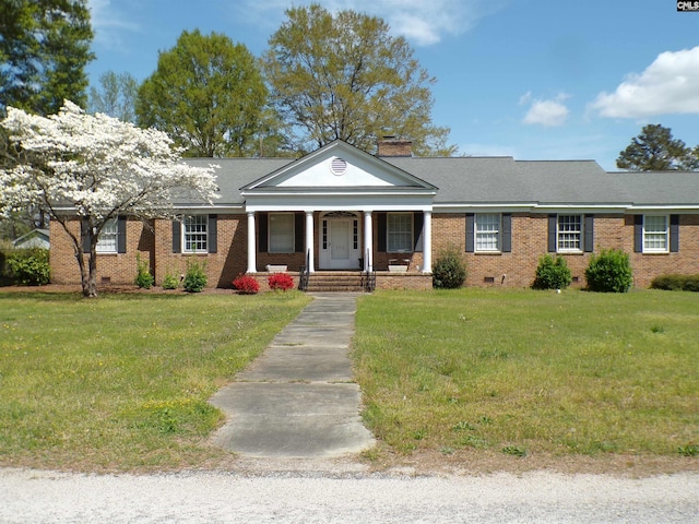302 Baskin Ave, Bishopville, SC 29010 - greek revival house with covered porch, a chimney, brick siding, and a front lawn