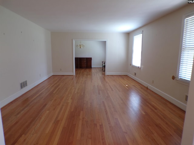 302 Baskin Ave, Bishopville, SC 29010 - spare room featuring plenty of natural light, visible vents, a notable chandelier, and light wood-type flooring