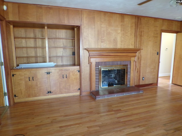 302 Baskin Ave, Bishopville, SC 29010 - unfurnished living room with a brick fireplace, built in features, wooden walls, and wood finished floors