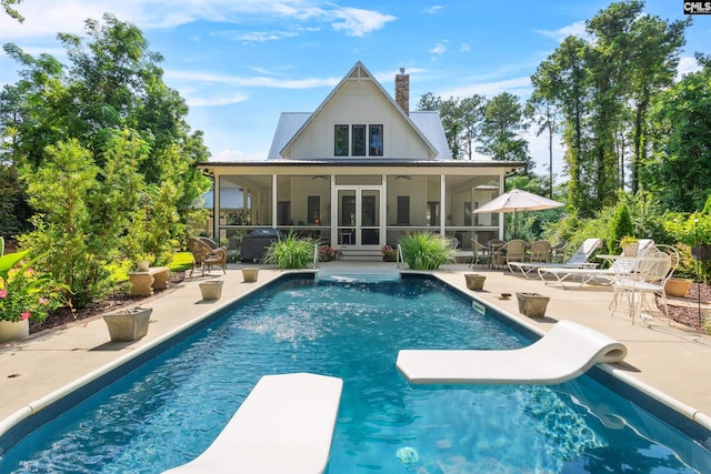 178 Pomaria St, Little Mountain, SC 29075 - rear view of house featuring a chimney, a sunroom, a patio area, and an outdoor pool