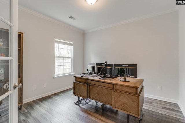 office featuring wood finished floors, crown molding, baseboards, and visible vents