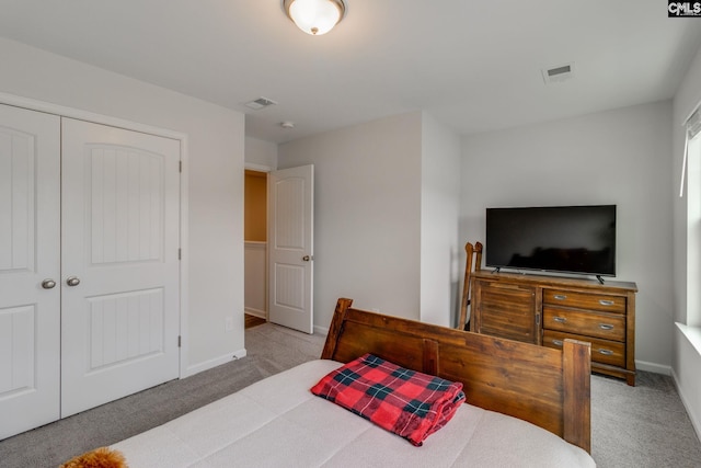 carpeted bedroom with baseboards, a closet, and visible vents