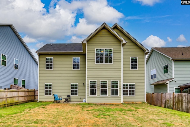 rear view of house with a lawn, a fenced backyard, and a patio