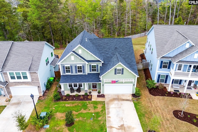 view of front of house with driveway, a front yard, and roof with shingles