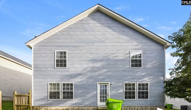 rear view of house featuring central air condition unit and fence