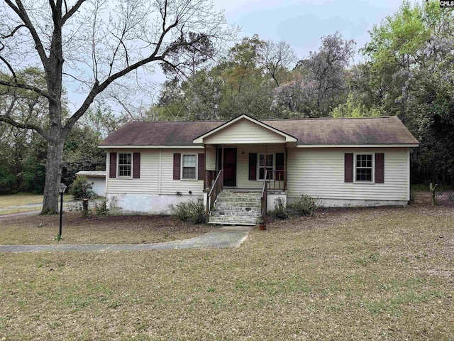 ranch-style house with covered porch and a front lawn