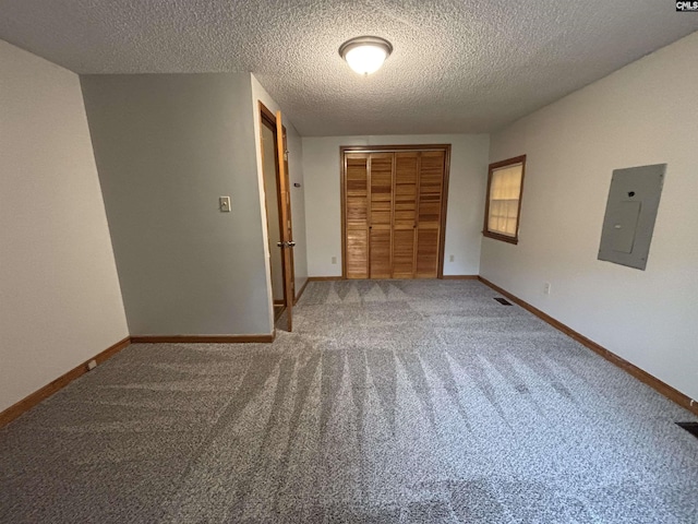 unfurnished bedroom featuring carpet floors, baseboards, a closet, and electric panel