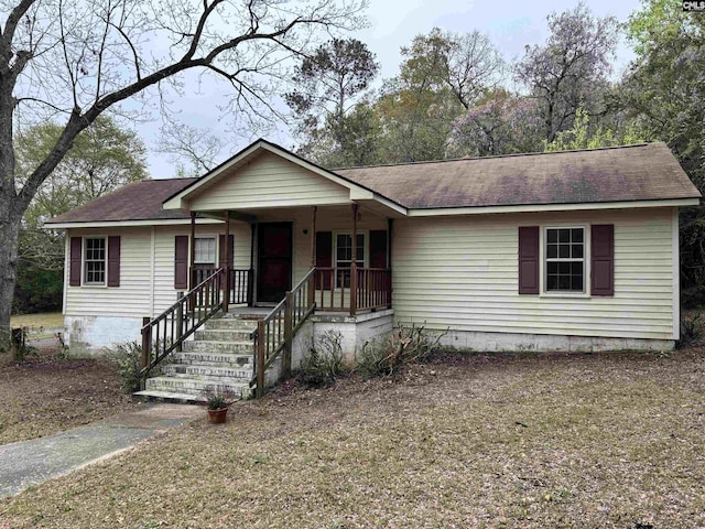 ranch-style house with covered porch and a shingled roof